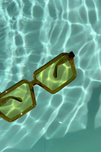 DELARGE green sunglasses in pool water.